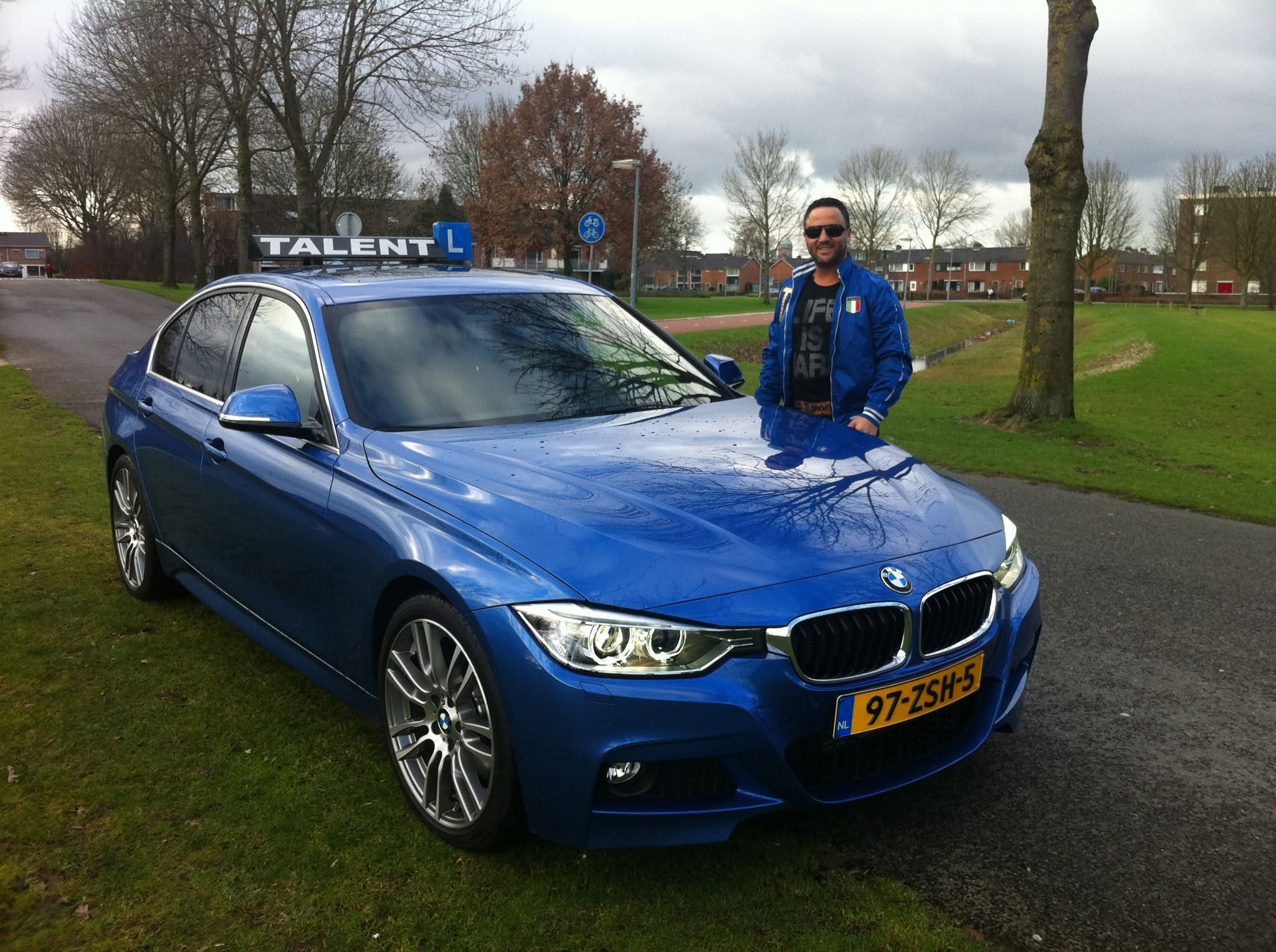 Ayhan bij de echte blauwe BMW lesauto van Rijschool Talent